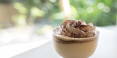 vanilla coffee chocolate pudding mousse in cup with green bokeh background